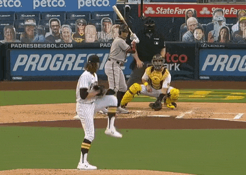 a baseball player swings his bat at a pitch in front of a petco banner