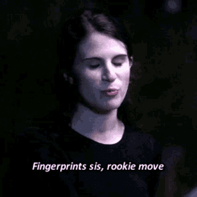 a woman in a black shirt is talking to a man in a dark room .