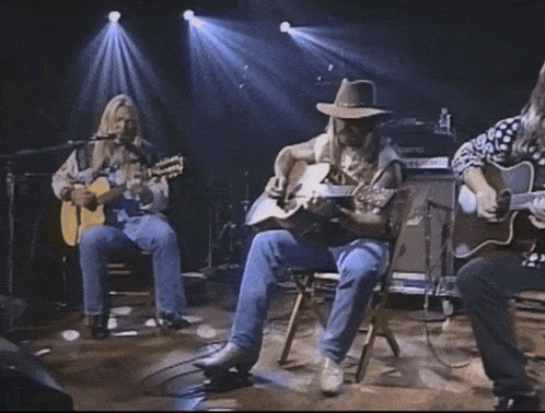 a man sitting on a stool with a guitar in his hand