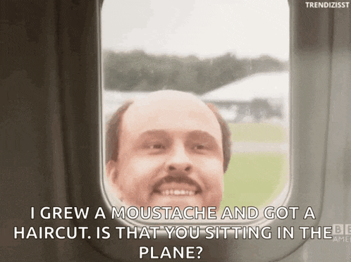 a man with a moustache is sitting in an airplane
