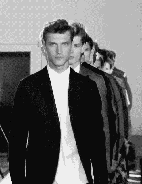 a black and white photo of men in suits