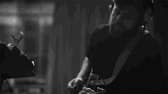 a man with a beard is playing an electric guitar