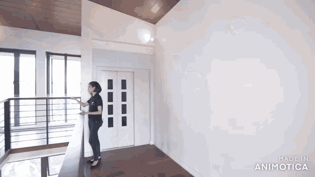 a woman standing in a room with the words made in animatica on the bottom right