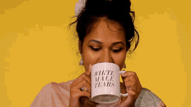 a woman is drinking from a white male tears mug