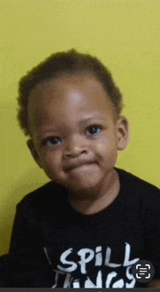 a young boy wearing a black shirt that says spill things
