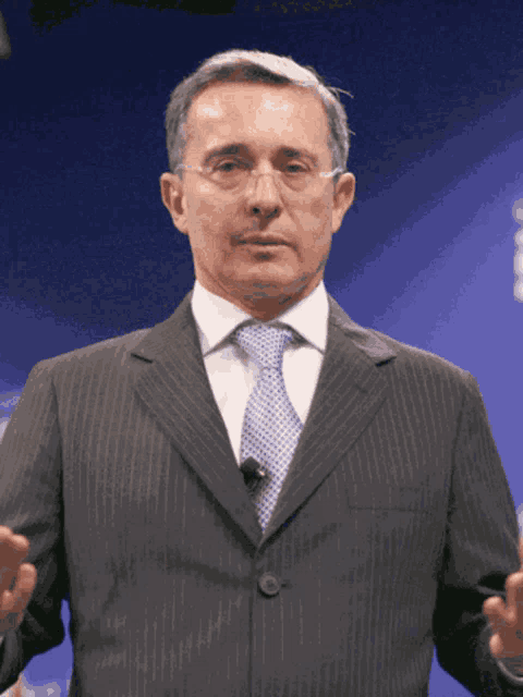 a man in a suit and tie is giving a presentation