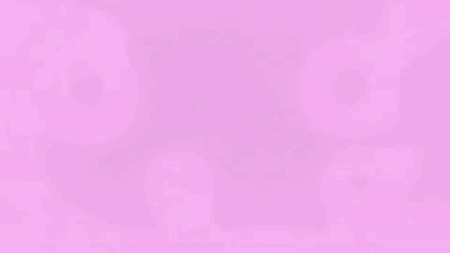 a man wearing glasses is sitting in a chair in front of a computer screen surrounded by pink bubbles .