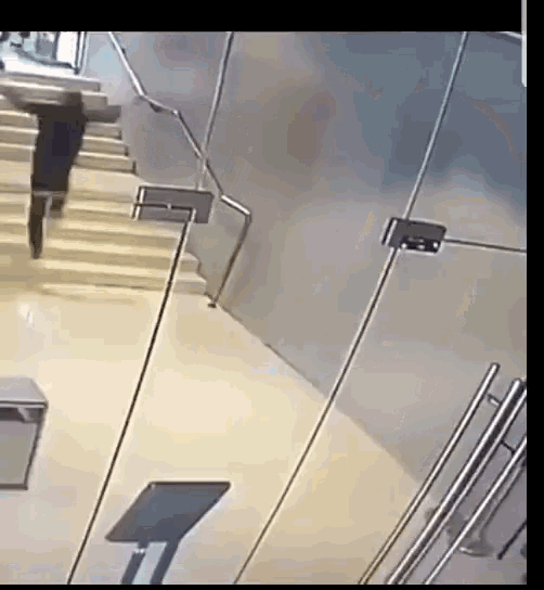 a man is walking down a set of stairs with a briefcase on his back .