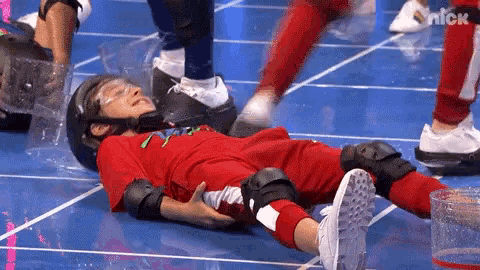a young boy is laying on the floor with a helmet on his head .
