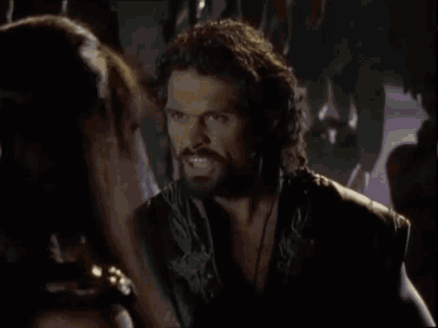 a man with a beard is talking to a woman and the words you 'll have it all are above him