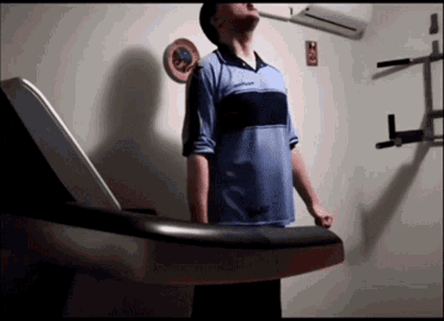 a man is standing on a treadmill in a room
