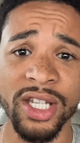a man with a beard is making a funny face with his mouth open .