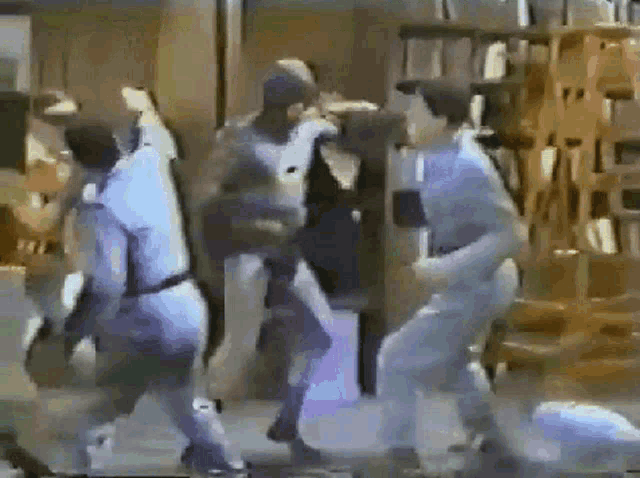 a group of people are standing in a room fighting