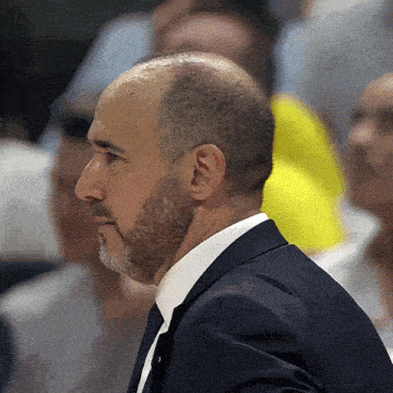 a man with a beard wearing a suit and white shirt
