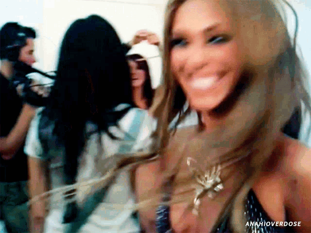 a woman with long hair is smiling in a blurry photo with anahioverdose written below her