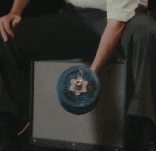 a man in a white shirt is lifting a blue dumbbell on a stool