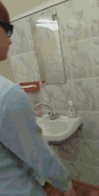a person standing in a bathroom next to a sink