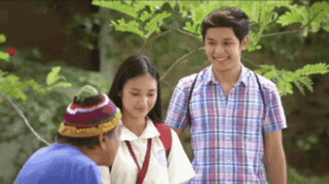 a boy and a girl are standing next to each other and talking to each other .