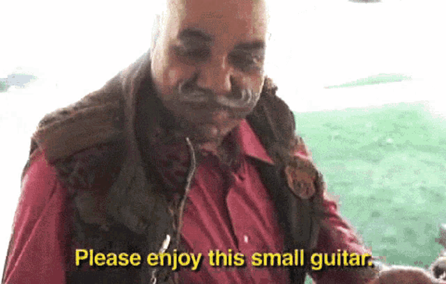 a man in a red shirt is holding a small guitar and says please enjoy this small guitar