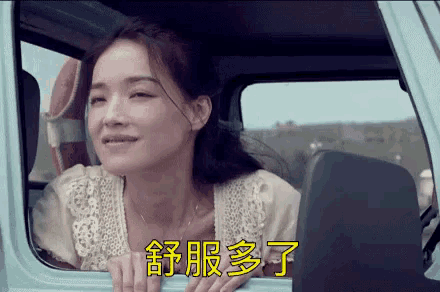 a woman is sitting in the driver 's seat of a car and looking out the window .
