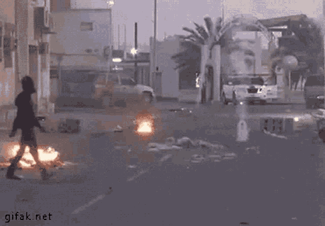 a man is running away from a large explosion on the street
