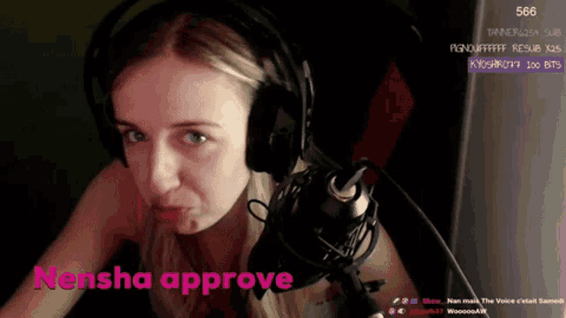 a woman wearing headphones is sitting in front of a microphone with the words " natasha approve " on the bottom right