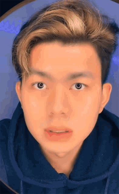 a close up of a young man 's face with a hoodie on
