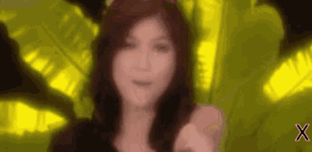 a blurry picture of a woman giving a thumbs up in front of a green background .