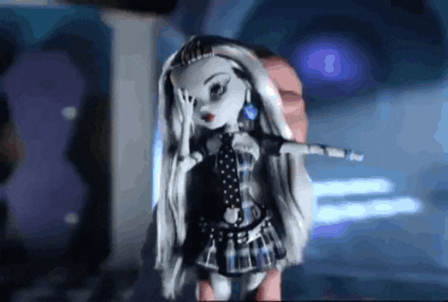 a person holding a monster high doll in their hand