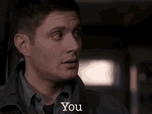 a man in a grey shirt says " you " in white letters