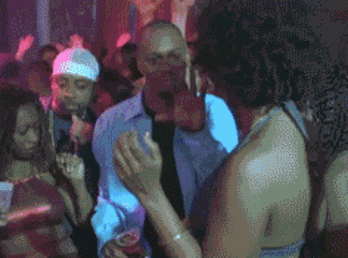 a man in a blue shirt is dancing with a woman in a red top