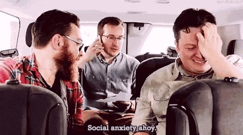 three men are sitting in the back seat of a car and one of them is saying social anxiety ahoy
