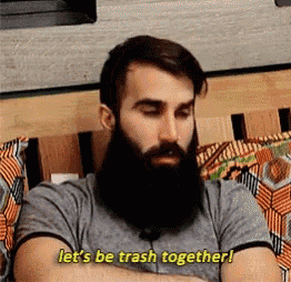 a man with a beard is sitting on a couch and saying `` let 's be trash together ''