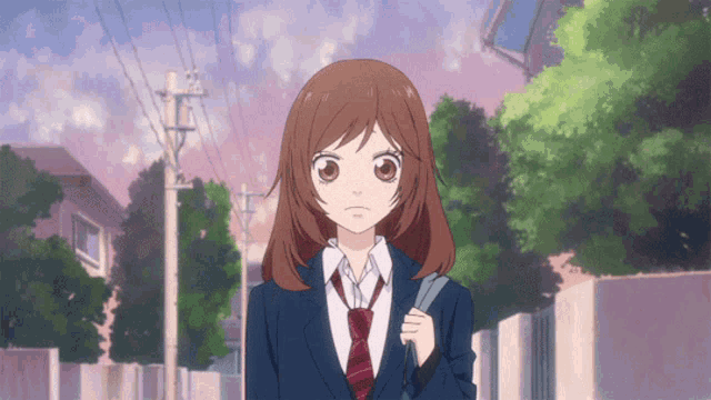 a girl in a suit and tie is walking down a street