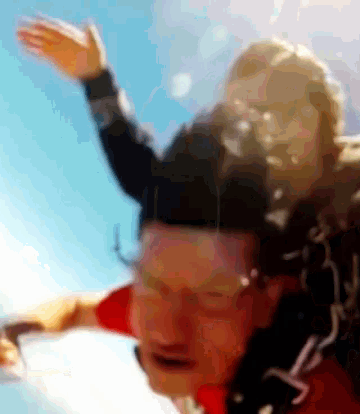 a man in a red shirt is being carried by another man