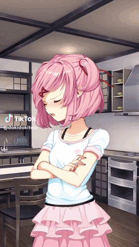 a girl with pink hair is standing in a kitchen with her arms crossed and a tiktok icon above her head