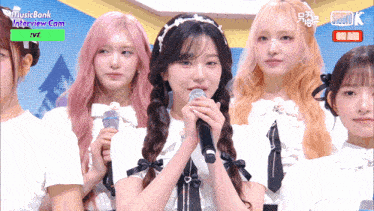 a group of girls standing in front of a screen that says musicbank interview.com