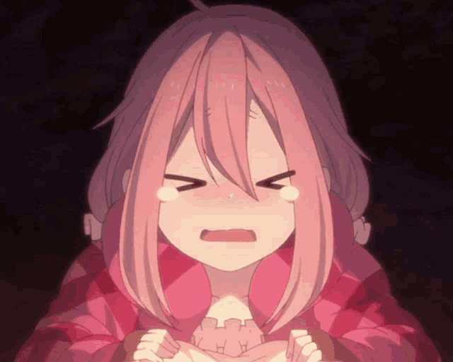 a girl with pink hair is crying and making a face