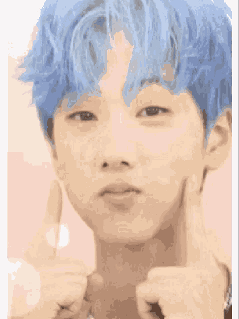 a boy with blue hair is giving a thumbs up sign .