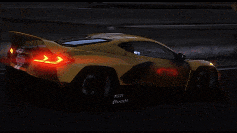 a yellow sports car is driving down a highway at night with a california license plate