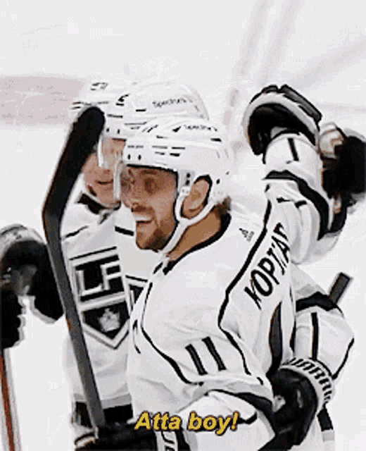 a hockey player says atta boy while holding his stick