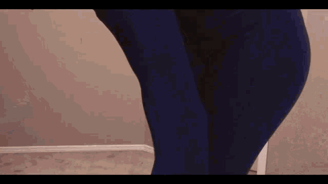 a person wearing blue pants is standing in a room .