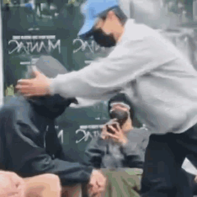 a man wearing a mask is giving a man a drink .
