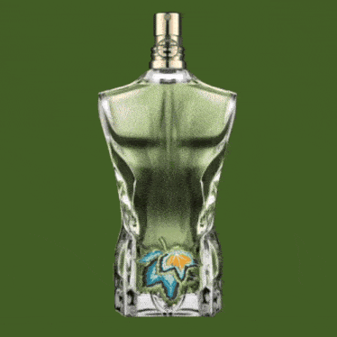 a bottle of perfume has a green background and a gold cap