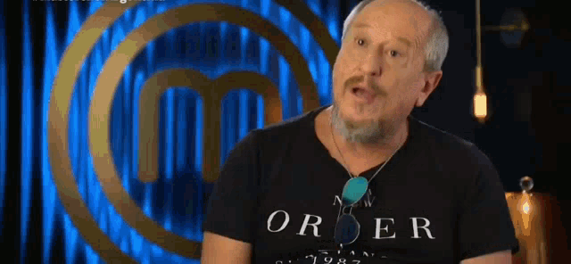 a man with a beard is wearing a black t-shirt that says order .