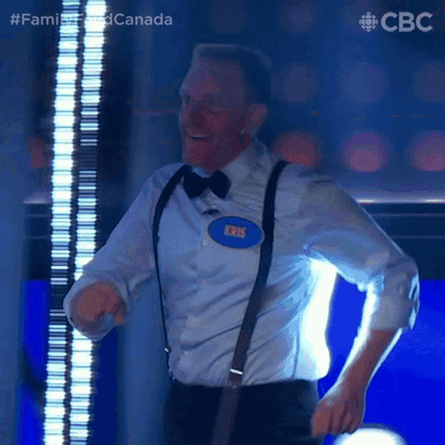 a man wearing a name tag that says kris is dancing on a stage .