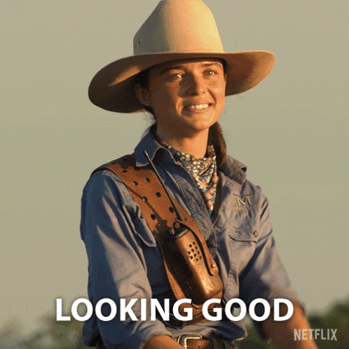 a woman in a cowboy hat is smiling with the words looking good below her
