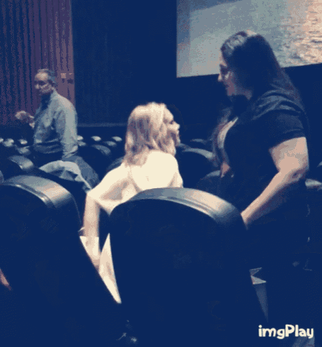 a couple hugging in front of a screen that says imgplay on it