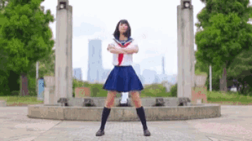 a girl in a school uniform is dancing in front of a fountain .