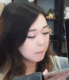 a close up of a woman 's face while looking at her phone
